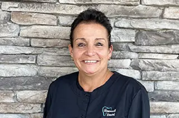 Sue, dental assistant, smiling at the dental office