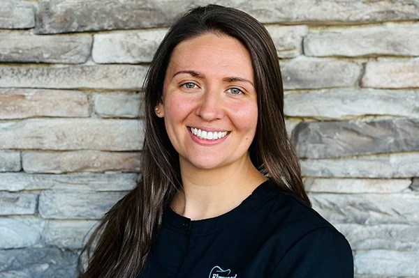 Sarah, dental hygienist, smiling at the dental office