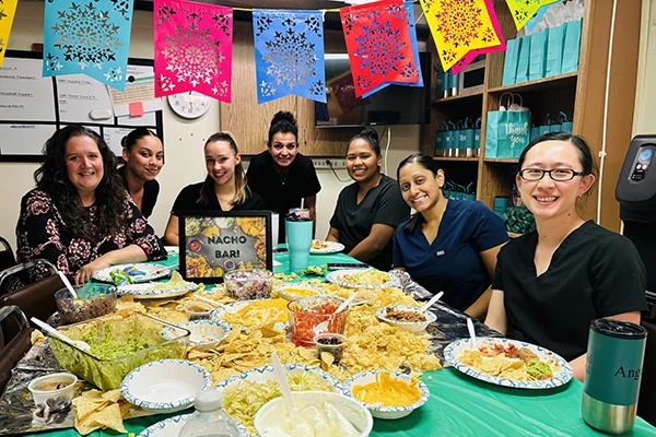 Team enjoying buffet-style meal with colorful paper decorations