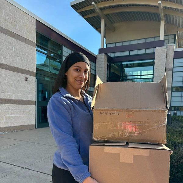 Staff carrying boxes for community outreach or donation