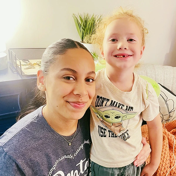Staff and child smiling together in casual office setting
