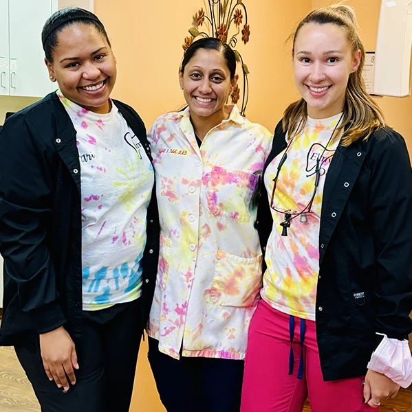 Team members in colorful scrubs posing for group photo