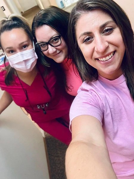 Selfie of three team members smiling closely together