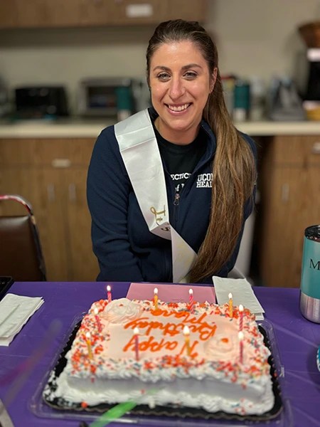 Staff celebrating with cake and decorated table