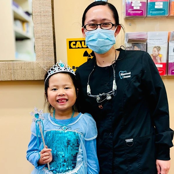 Dentist and child patient smiling together in clinic