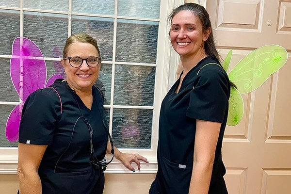 Staff smiling in green wings during team event