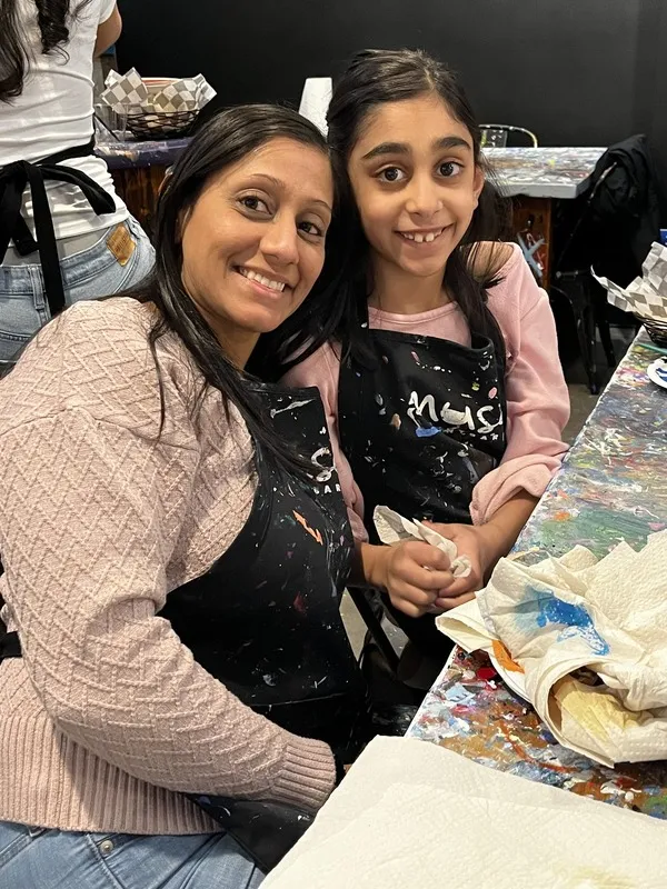 Adult and child smiling together at art class